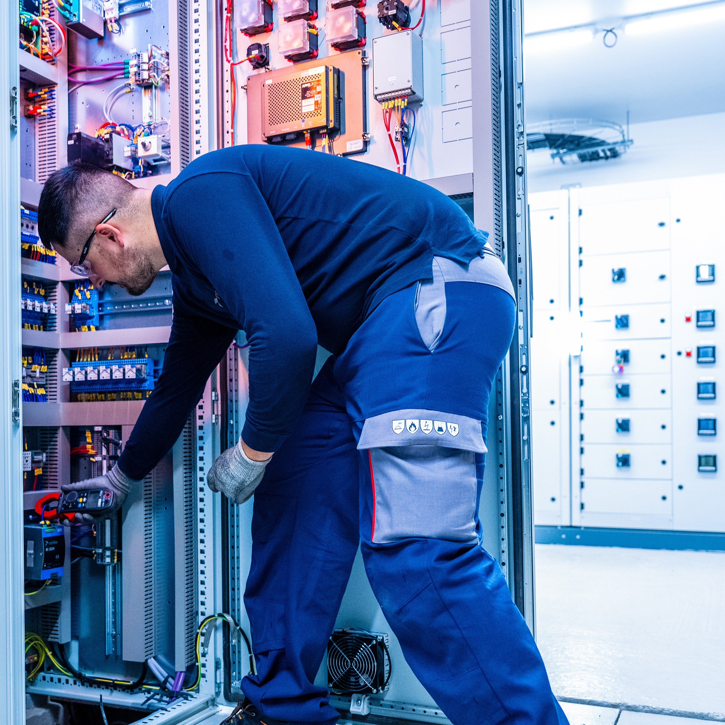 Man in blue uniform working on a large equipment.
